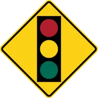 Yellow diamond warning sign showing a traffic light with red, yellow and green lights.
