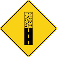 Yellow diamond sign with a smooth black band changing to a speckled, rough-textured band.