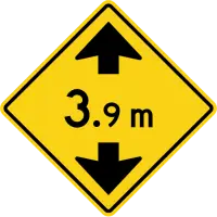 Yellow diamond sign with black arrows pointing toward each other above and below the figure 3.9 m.